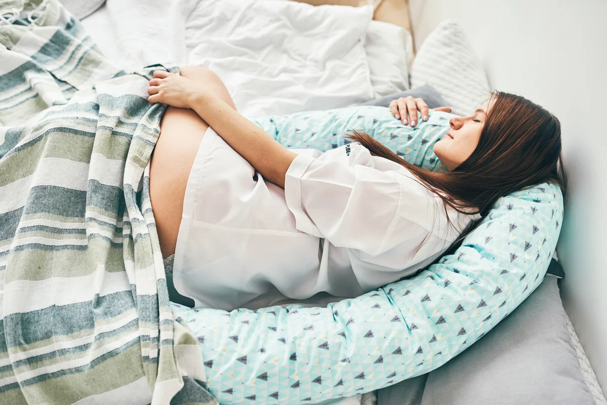 Pregnant woman sleeping with pregnancy pillow