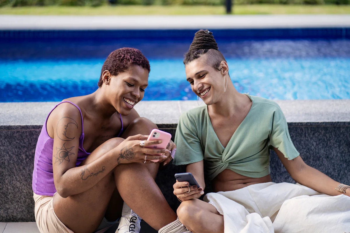 Portrait of transgender woman friends using smart phone
