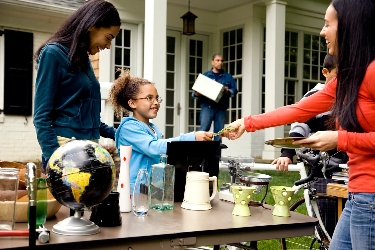 Mother and daughter paying at a garage sale