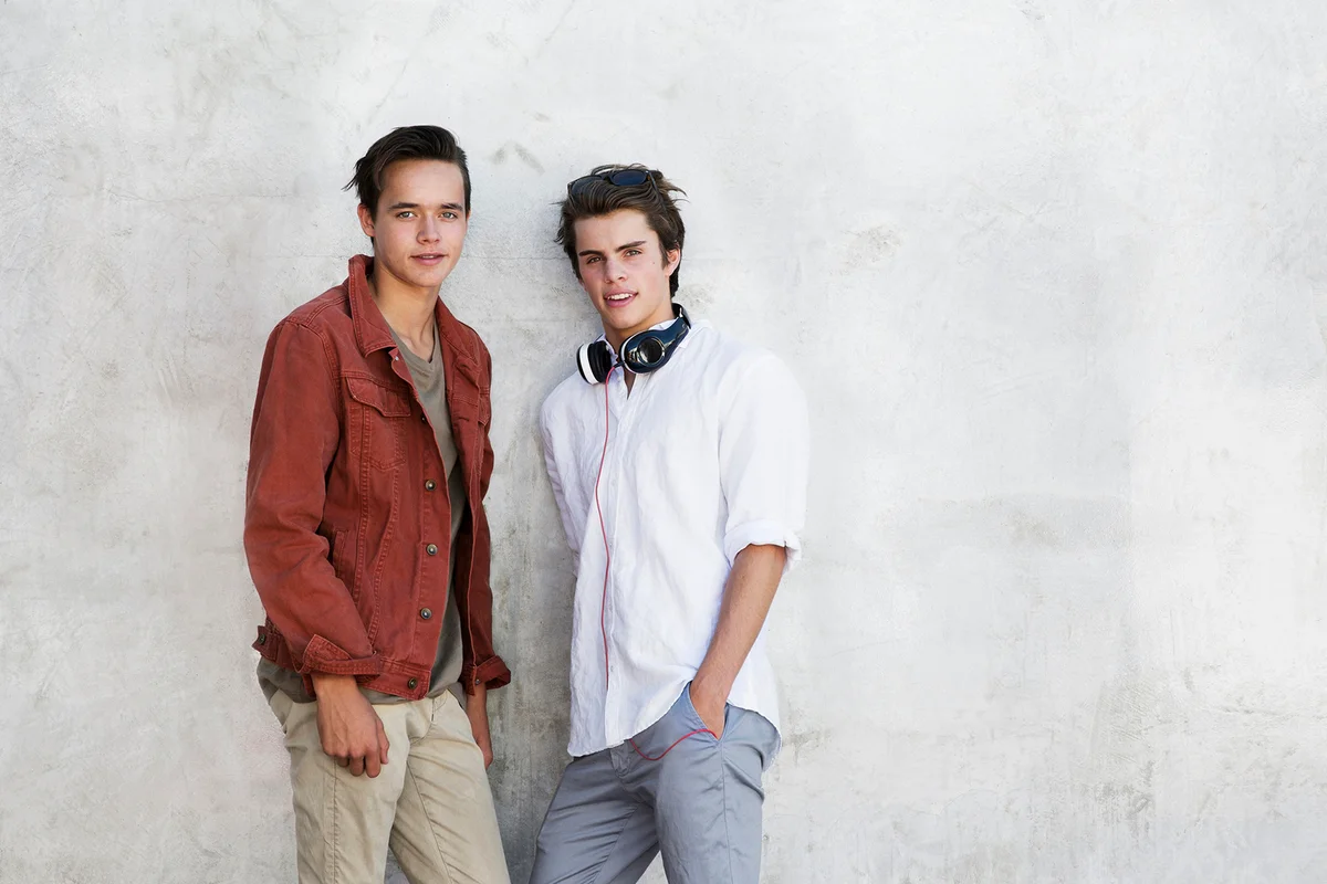 Teenage friends portraits by a grey wall