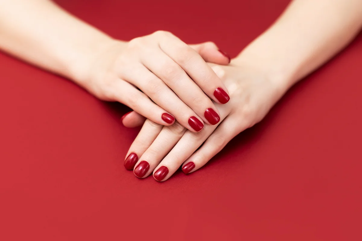 Female hand with shiny red nails