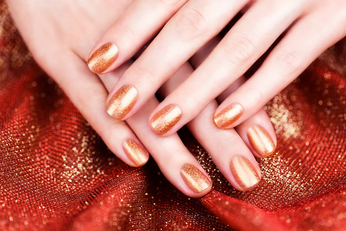 Female hands with bronze-colored manicure
