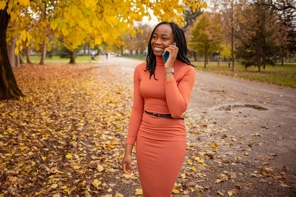 Carefree woman at the public park during autumn day