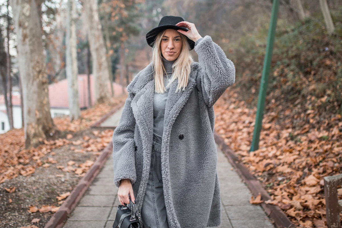 Woman wearing a hat walking in park on cold day