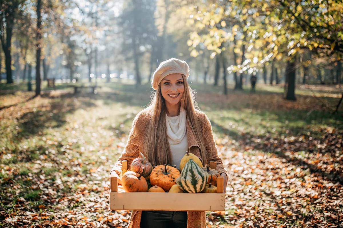 Woman carrying pumpkin and squash