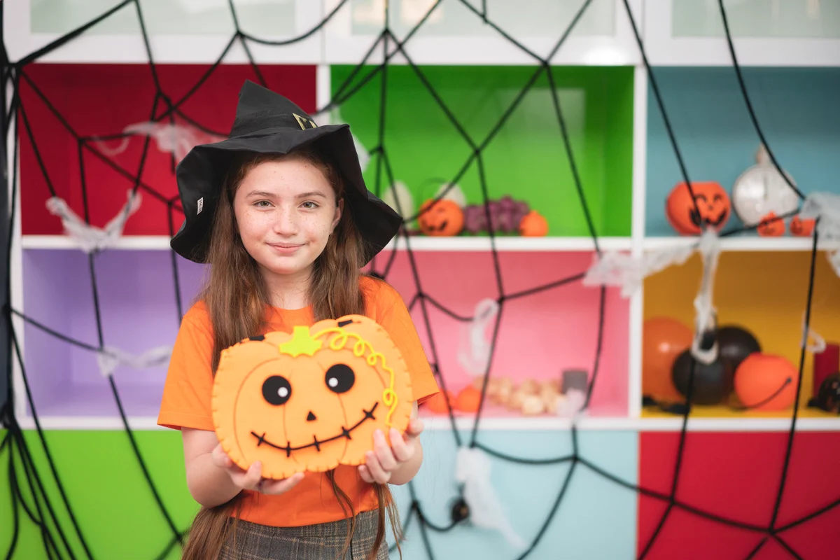 Happy laughing child girl in witch costume to halloween