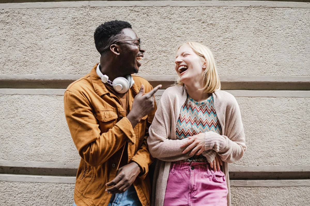 Friends smiling and standing on the street