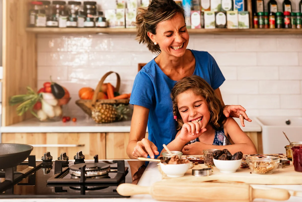 Girl and mom laughing in kitchen
