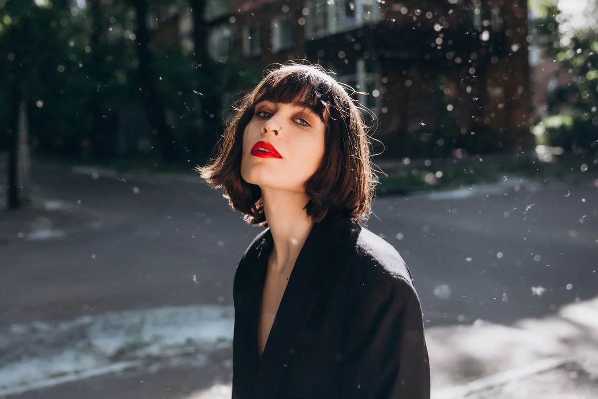 Outdoor portrait of young brunette in black jacket