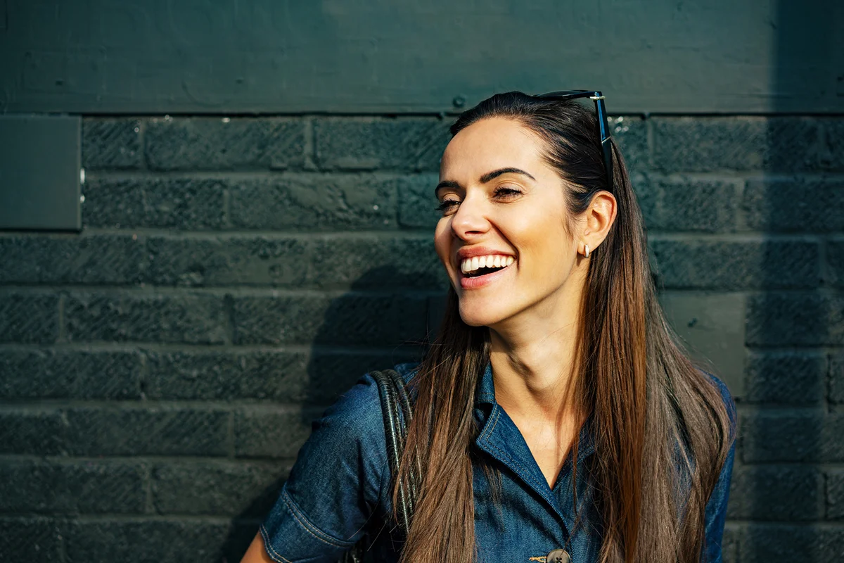 Happy woman laughing off camera