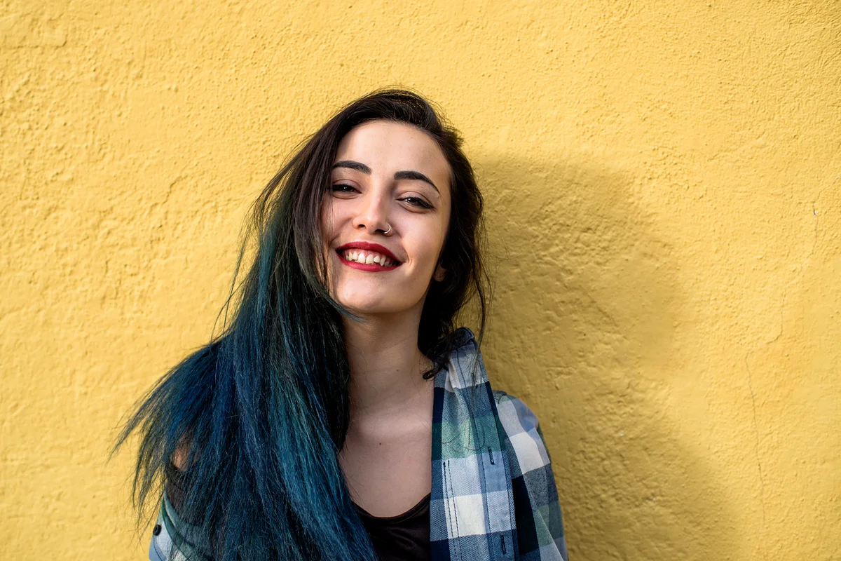 Portrait of young and beatiful girl in front of yellow wall