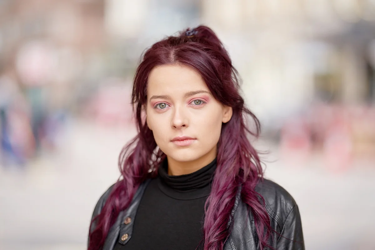 Woman with Purple hair and a wearing a leather jacket
