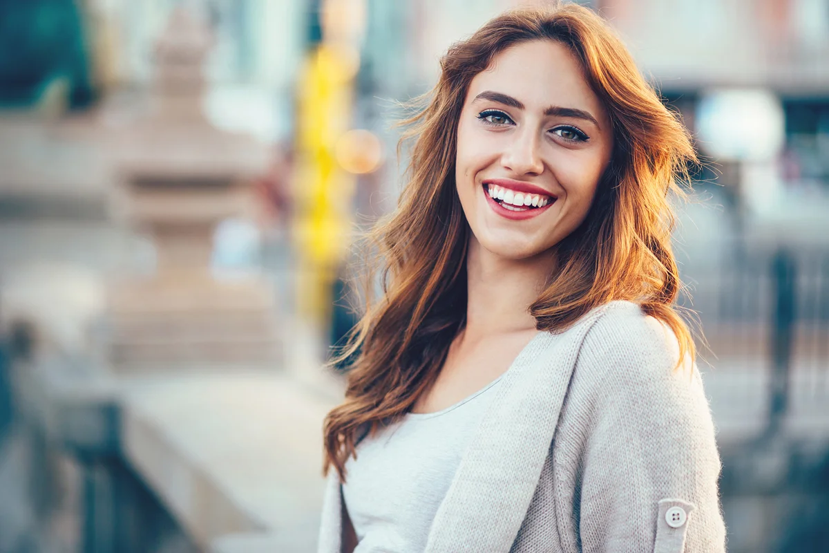 Portrait of happy young woman at urban scene