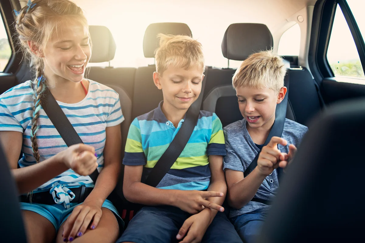 Kids playing games in car during road trip