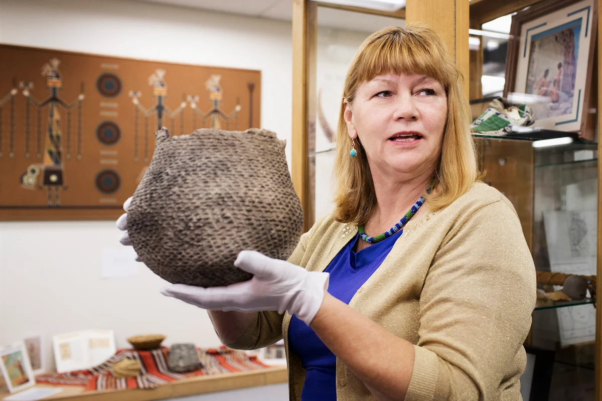 Caucasian curator holding artifact in museum