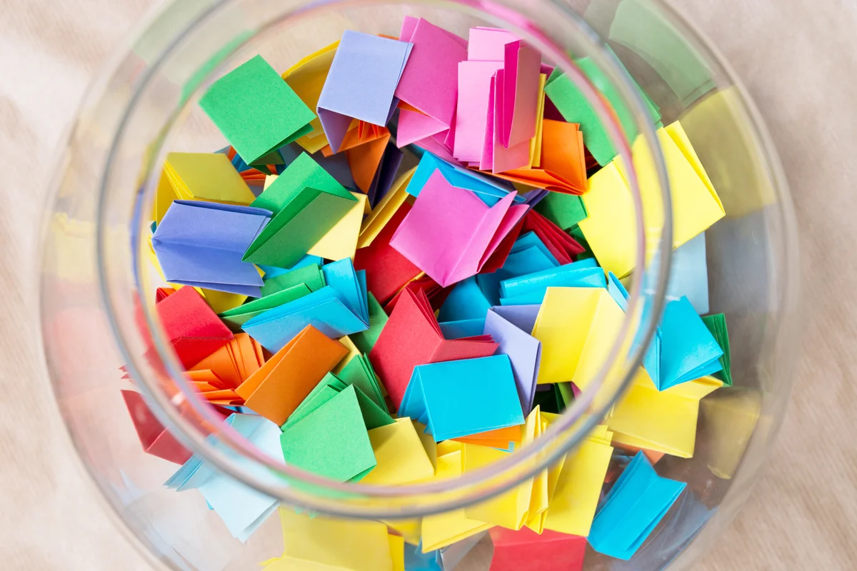 Multicolored lottery tickets in jar closeup