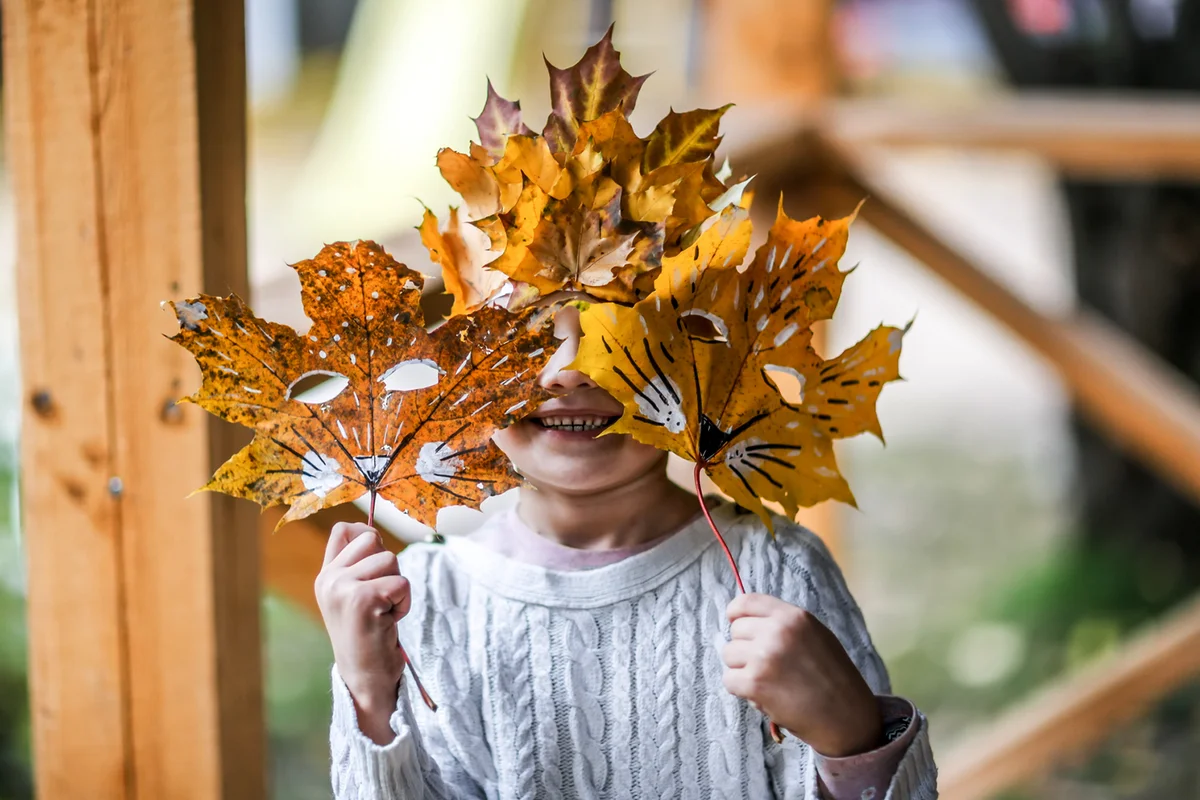 Cute Girl Conceals Behind Hand-Drawn Leaf Masks