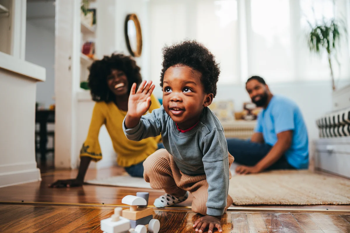 A happy toddler is playing with a wooden educational Montessori train toy