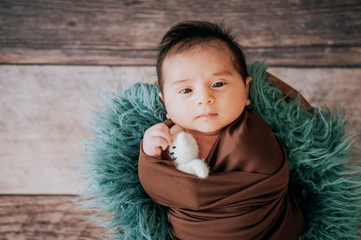 Little baby boy with knitted hat in a basket