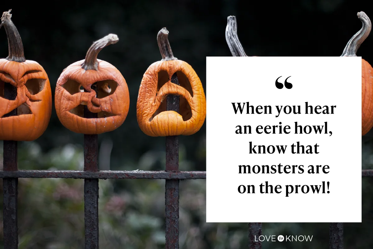 Row of carved pumpkins impaled on fence
