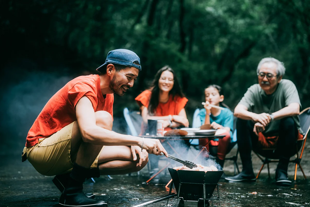 Man enjoying BBQ with family in nature