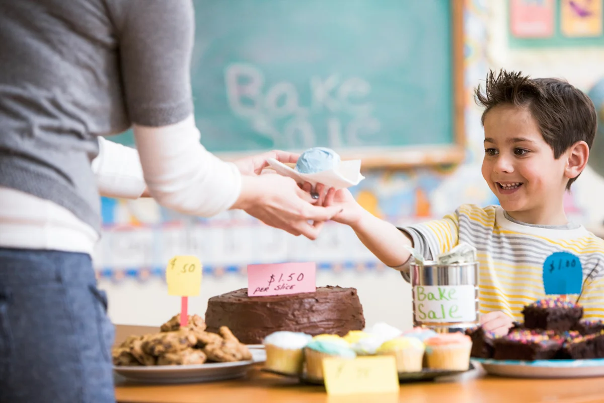 boy buying cupcake at bake sale