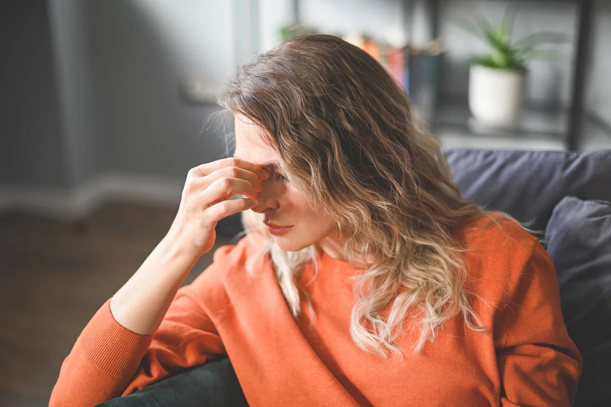 Woman frustrated on couch (negative emotions)
