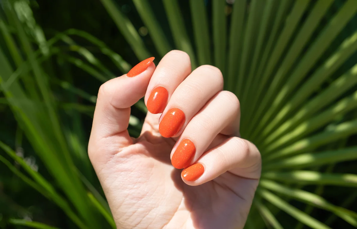 Female hand with orange nail design