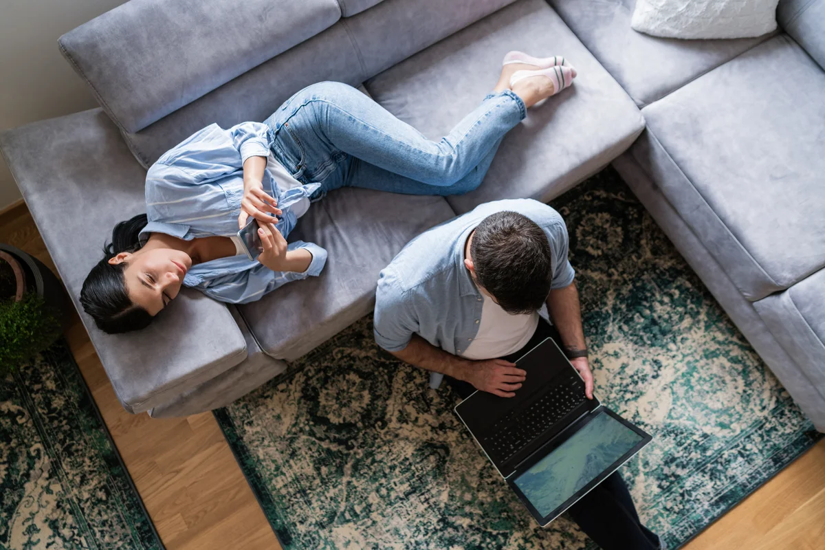 Man does work computer while woman is on phone