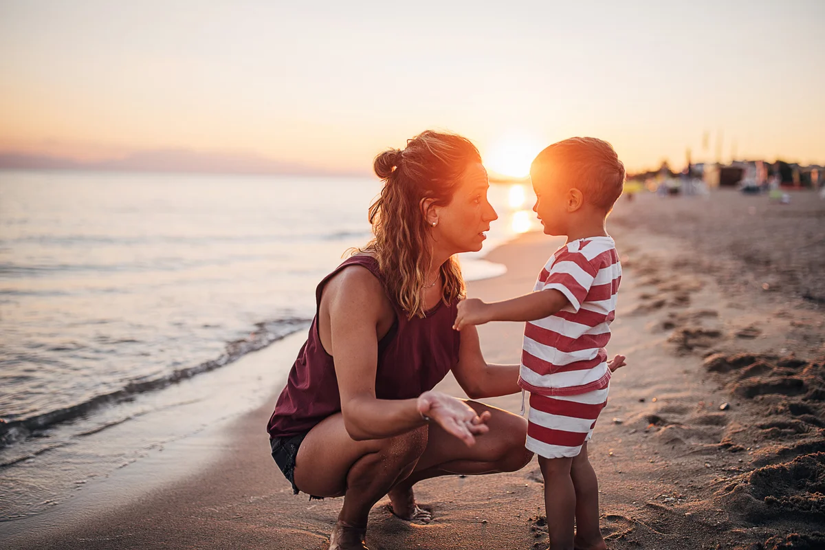 Mom and toddler talking at the beach
