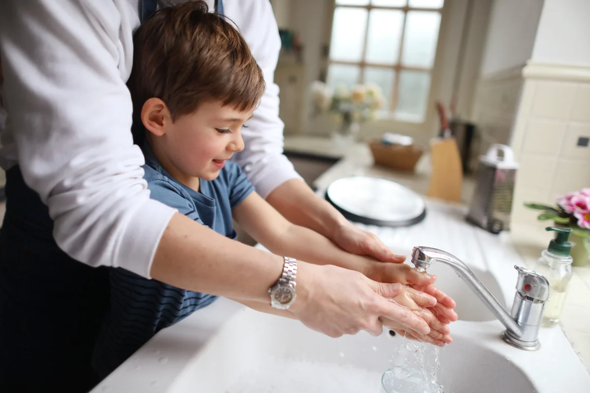 Toddler and parent washing hands together