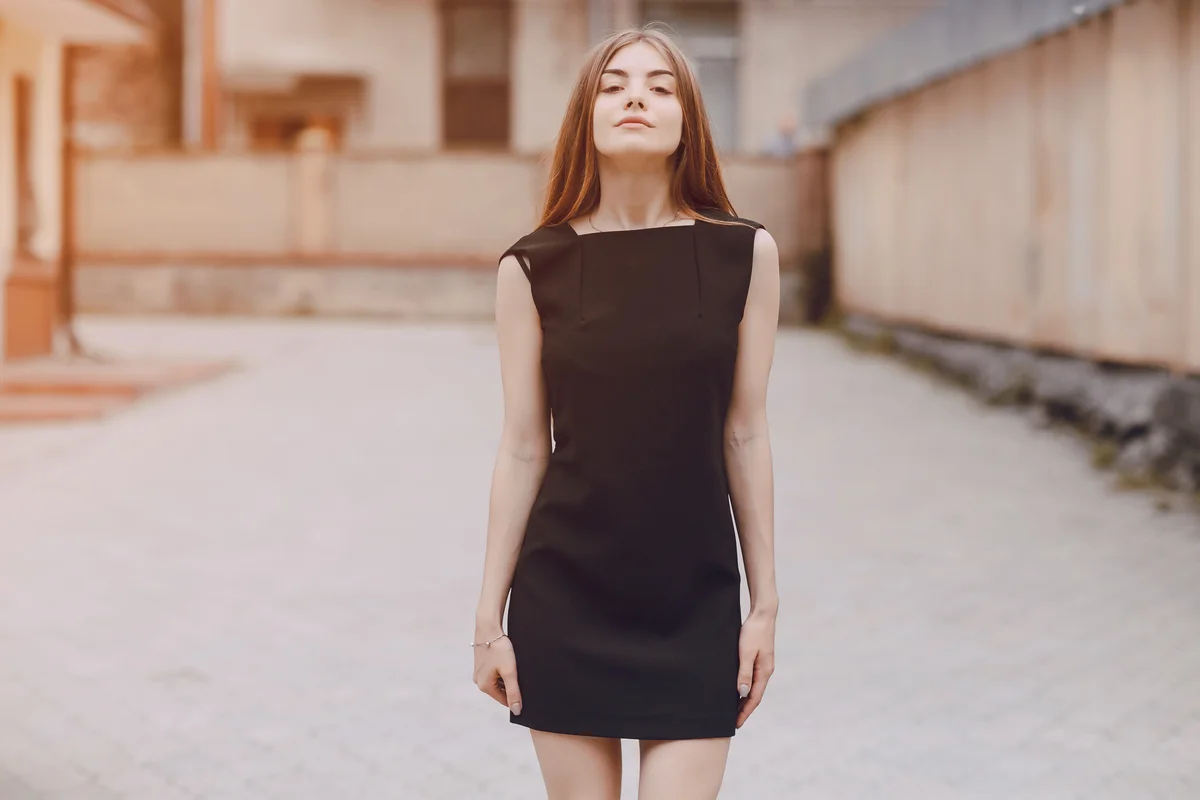 Teenager posing while wearing black dress