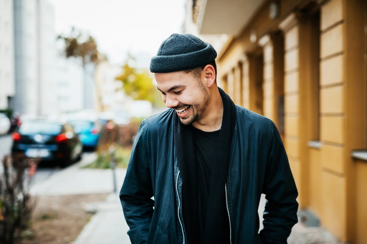 young man in black clothes walking down the street