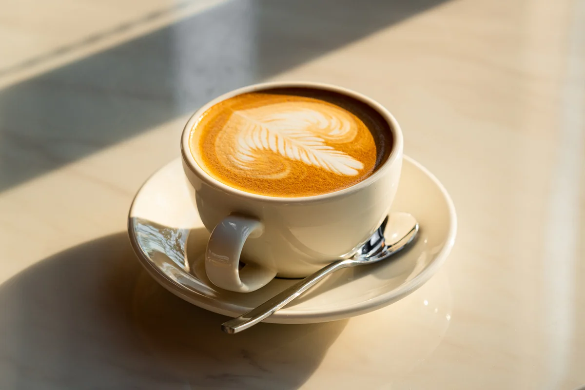 Freshly brewed latte coffee on a white table