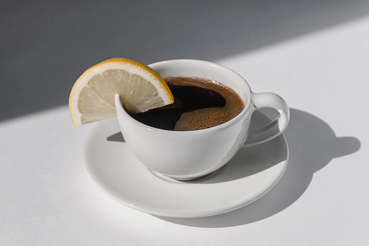 Coffee cup with espresso served with lemon