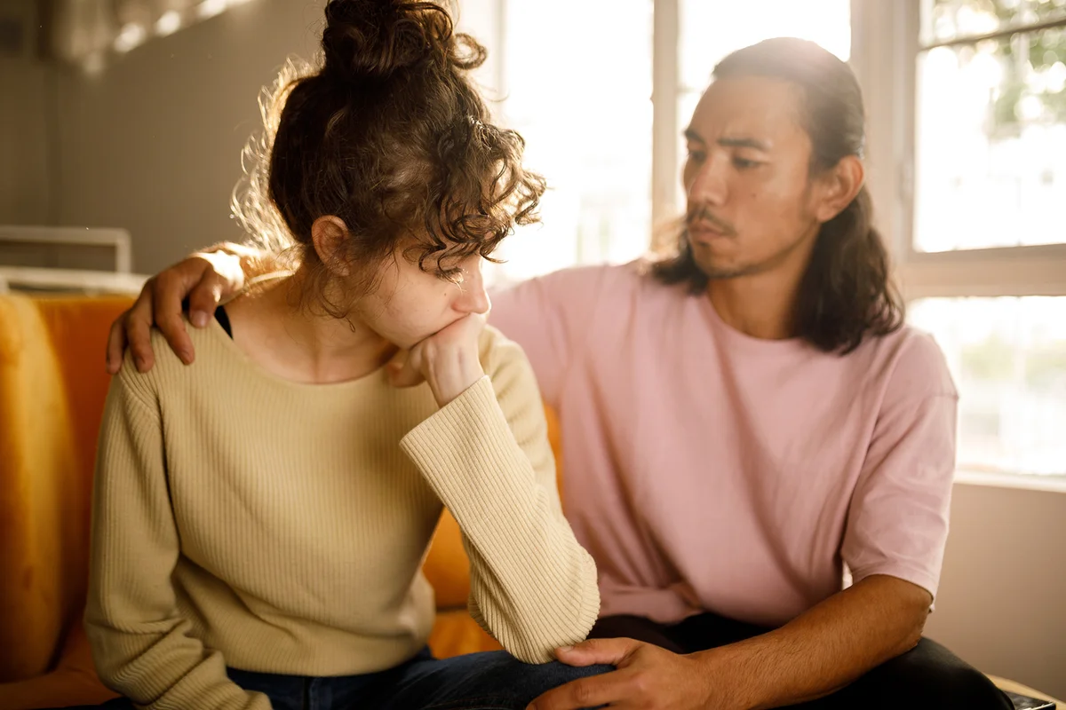 Man giving his distressed friend emotional support during difficult moments