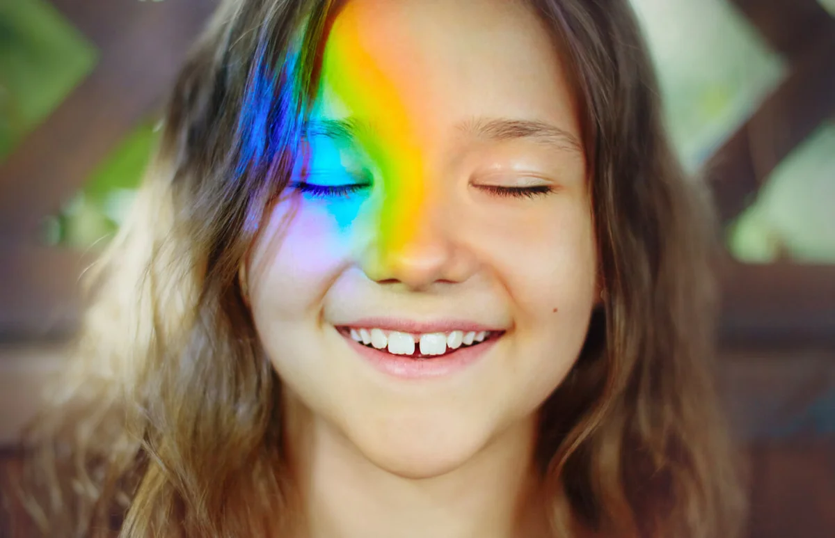 smiling girl with a rainbow on her face
