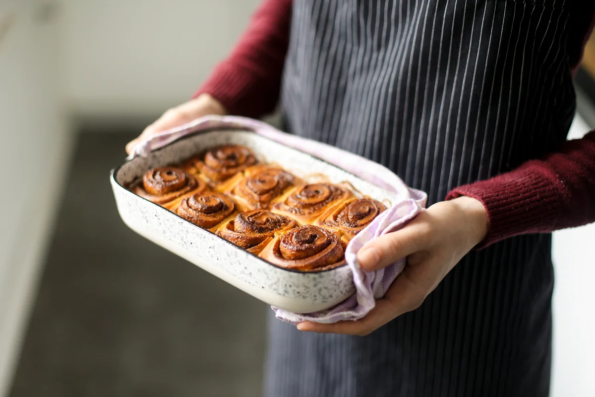 young woman holding cinnamon buns