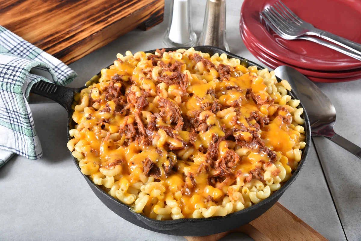Cast iron skillet with macaroni and cheese with barbecued beef