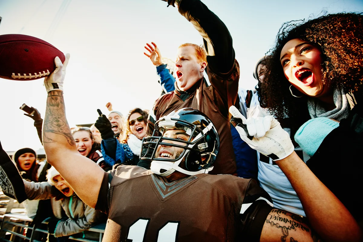 Professional football quarterback celebrating touchdown with fans in stadium