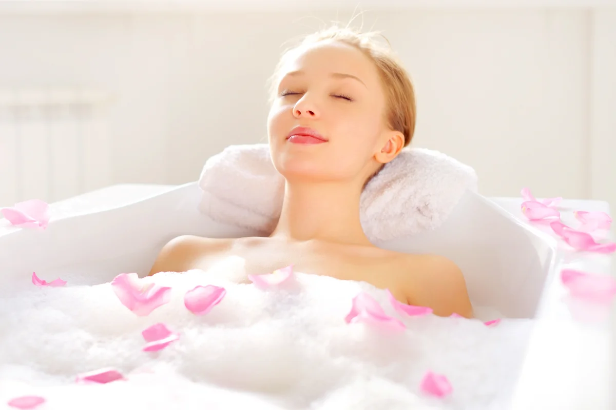 Woman relaxing in rose petals bath