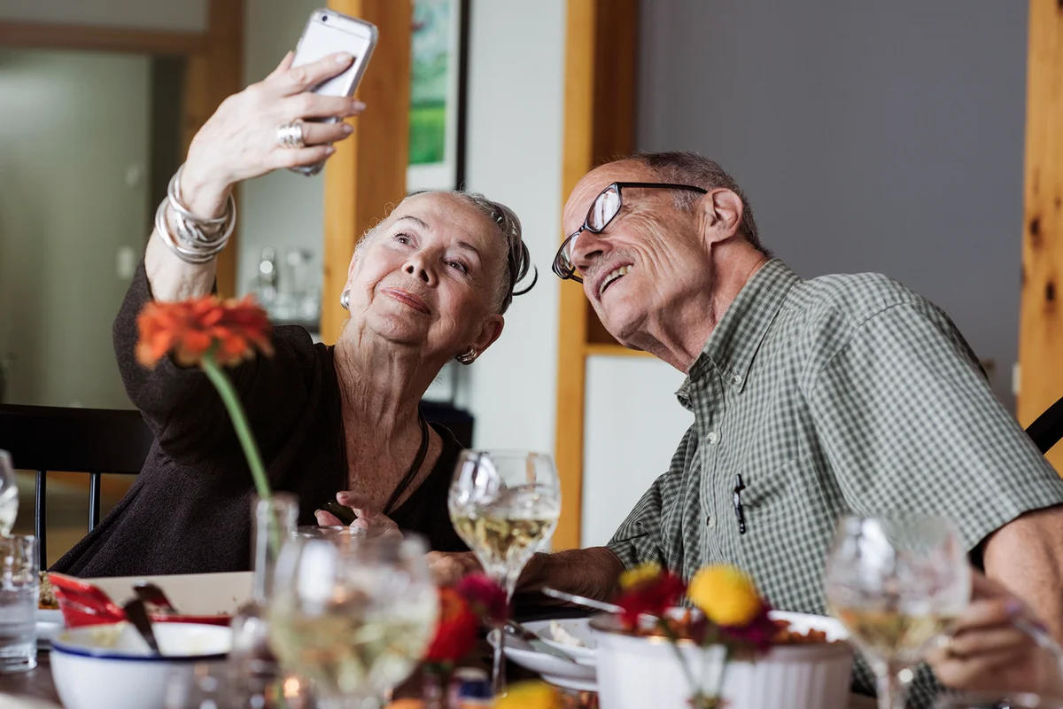 Senior couple taking selfie through smart phone during Thanksgiving at home