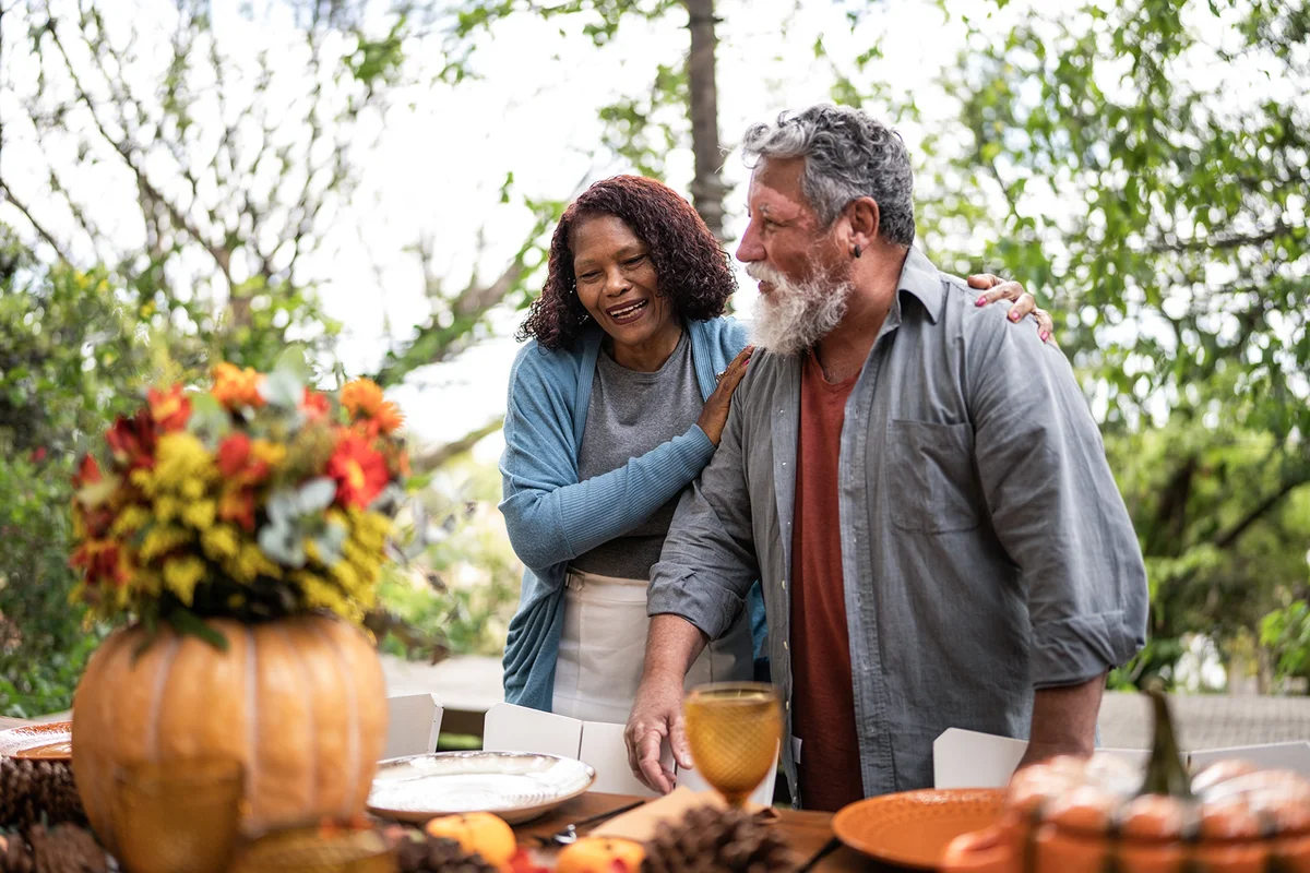 Senior couple setting the table for Thanksgiving at home