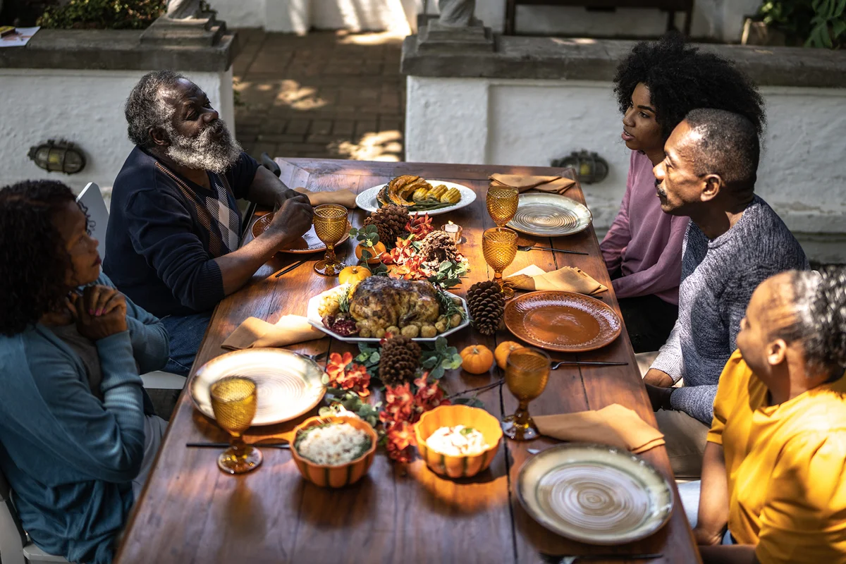 Family saying grace before Thanksgiving lunch at home