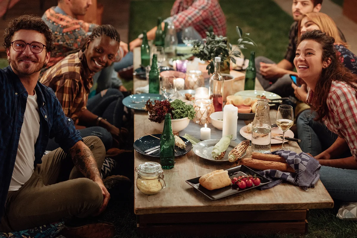 Young friends taking selfie at dinner party
