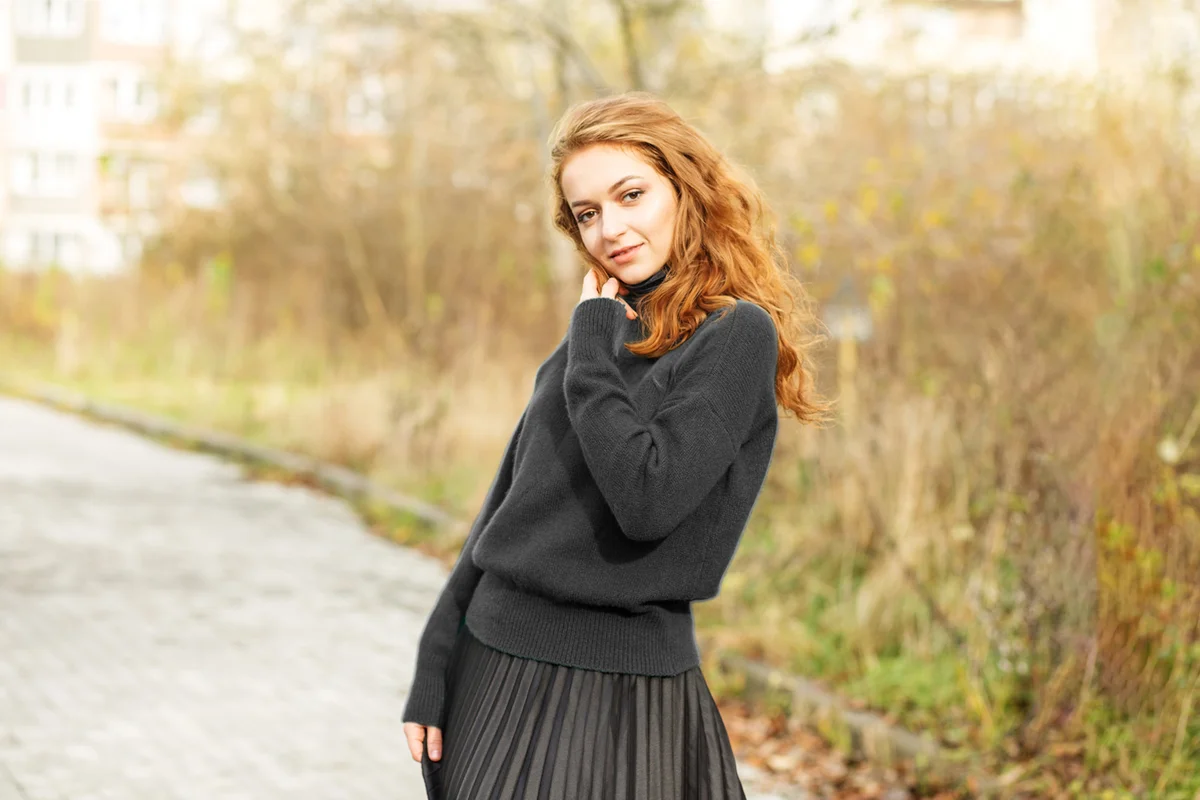 Beautiful red-haired woman in a pleated skirt
