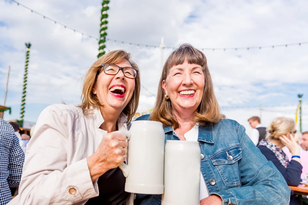 Two retired active senior pensioners enjoying time together while visiting Beer Fest in Munich