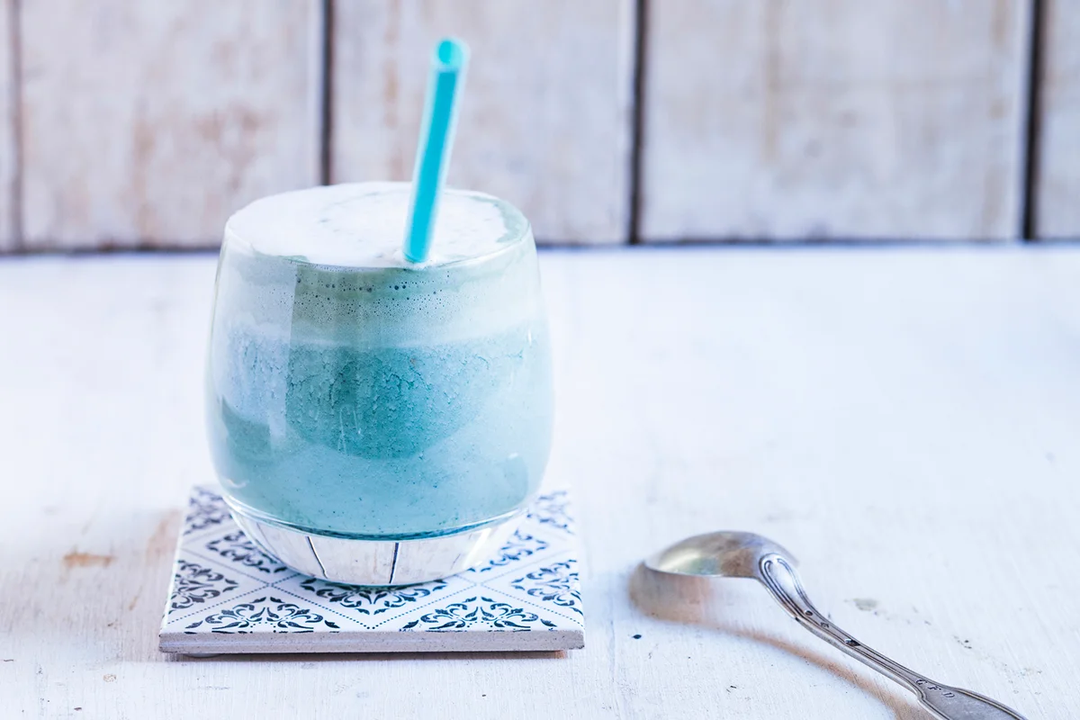 Glass of blue coloured latte