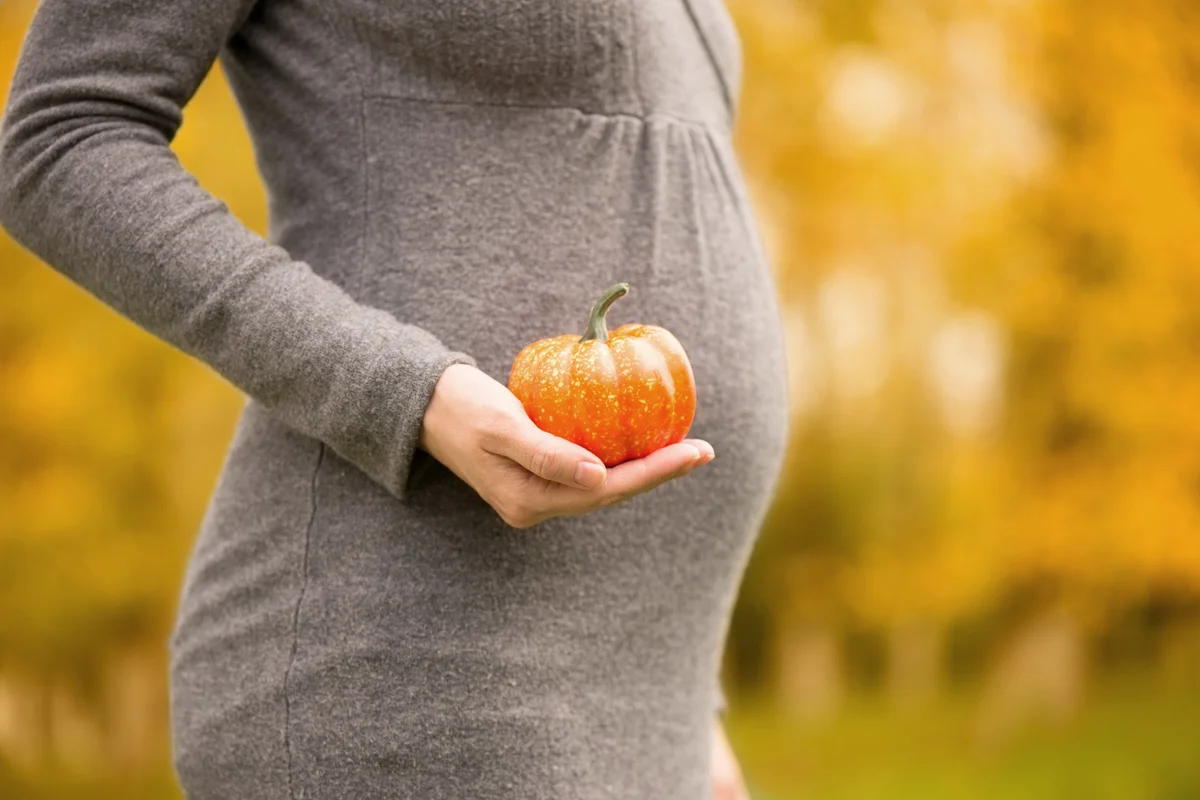 Pregnant woman holding small gourd