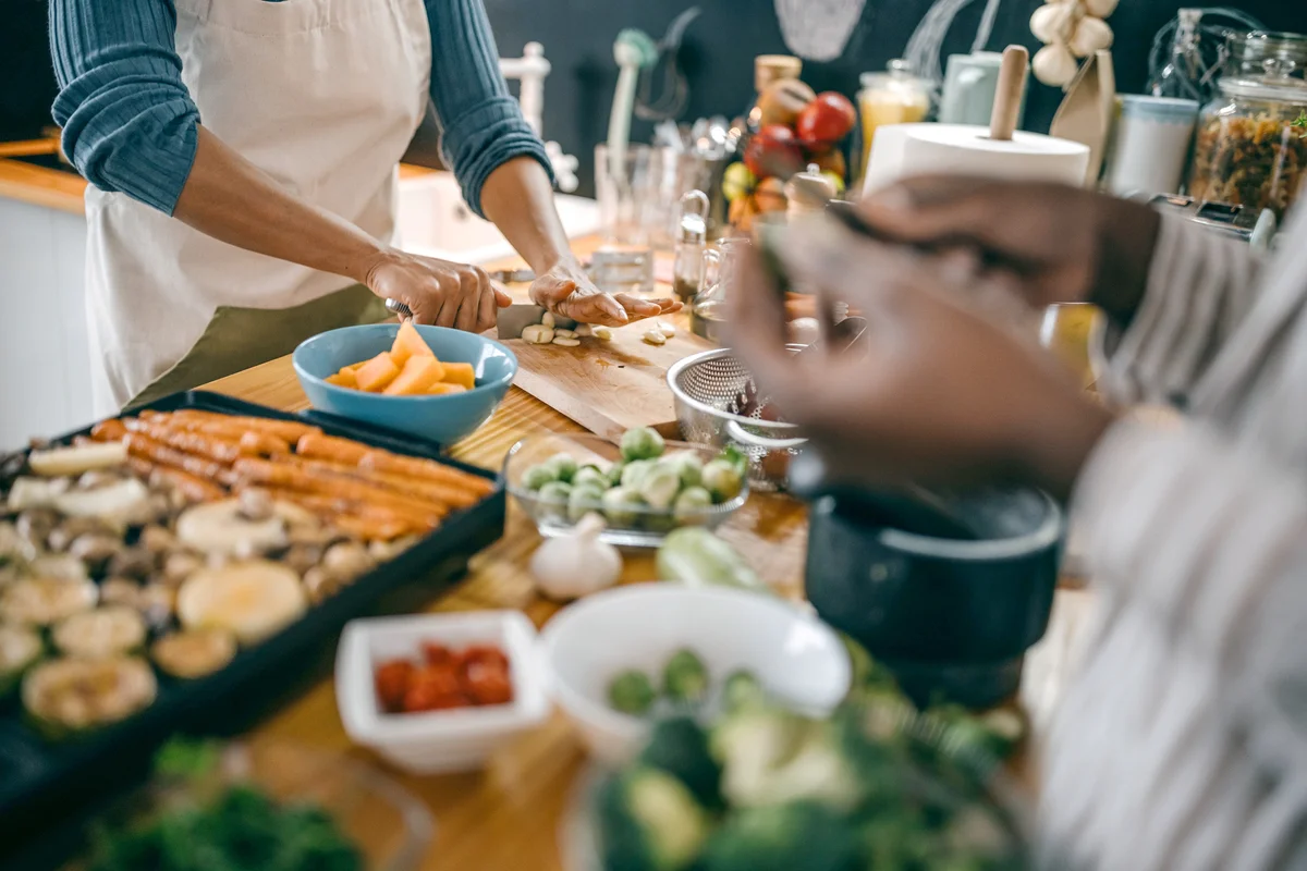 Women cutting vegetables in kitchen in preparation for Thanksgiving
